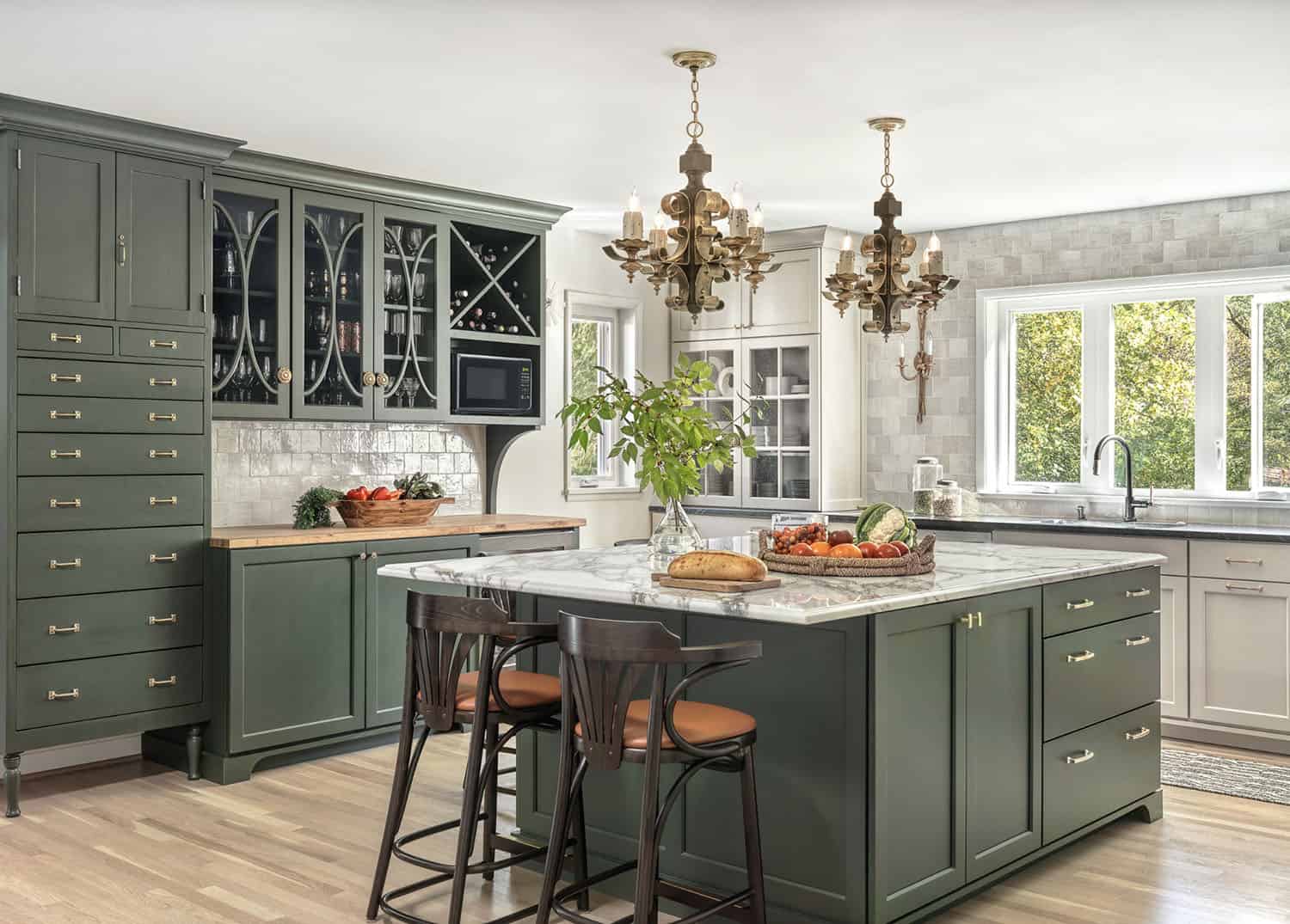 transitional style kitchen with green and cream colored cabinets