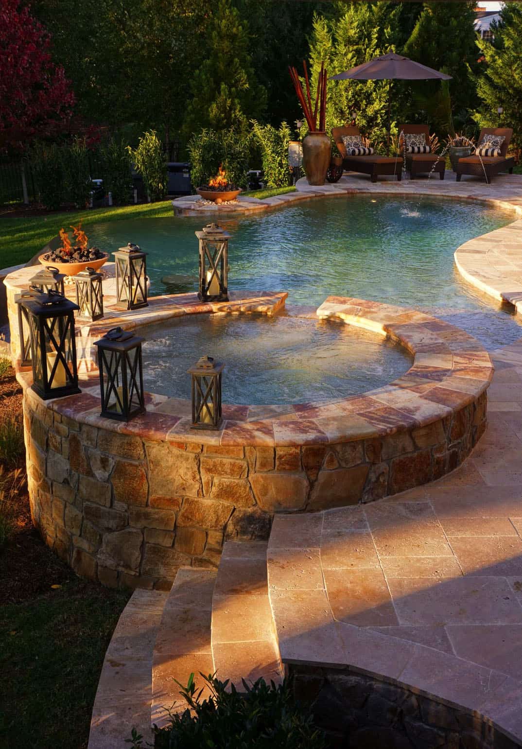 hot tub flowing into pool with rock pool deck 