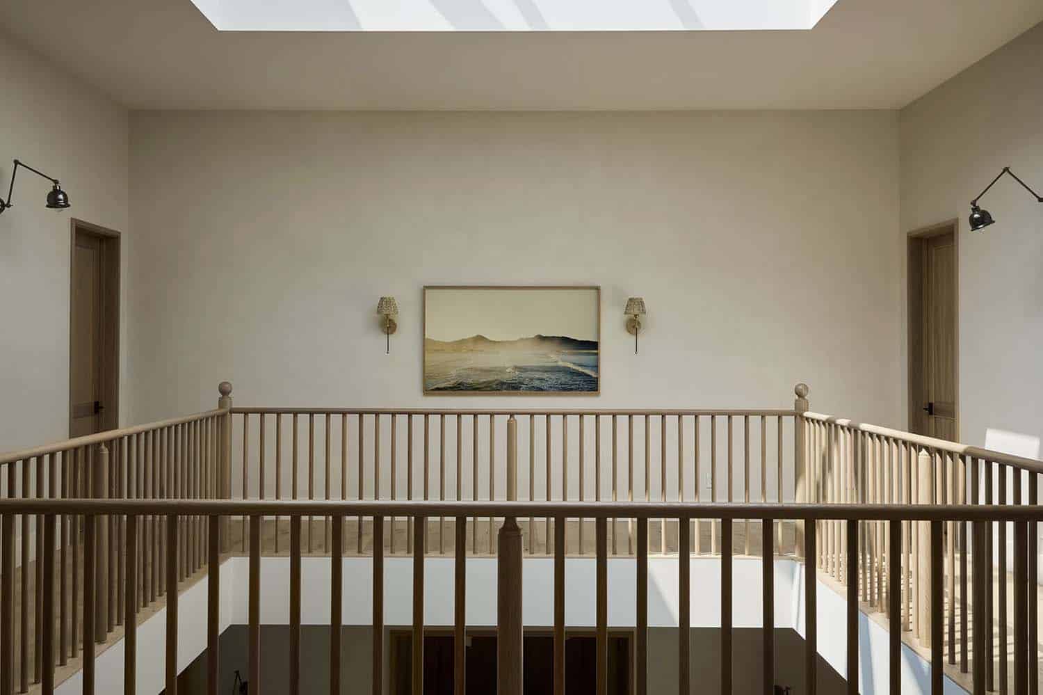 transitional style upstairs hallway with a skylight