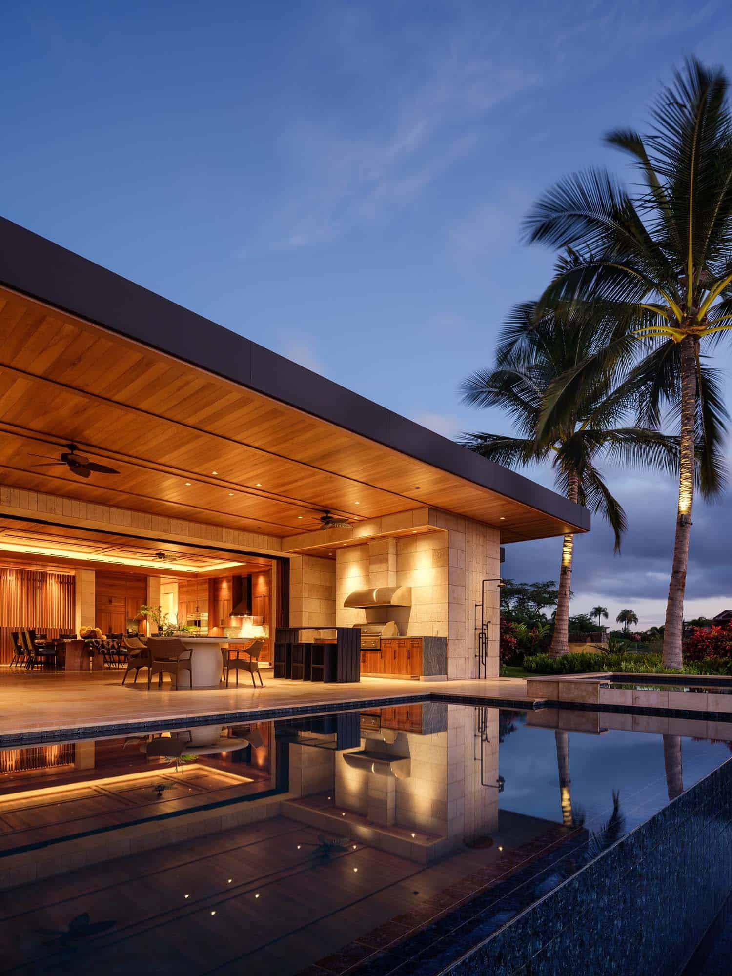 contemporary beach house with a backyard view of the pool at dusk