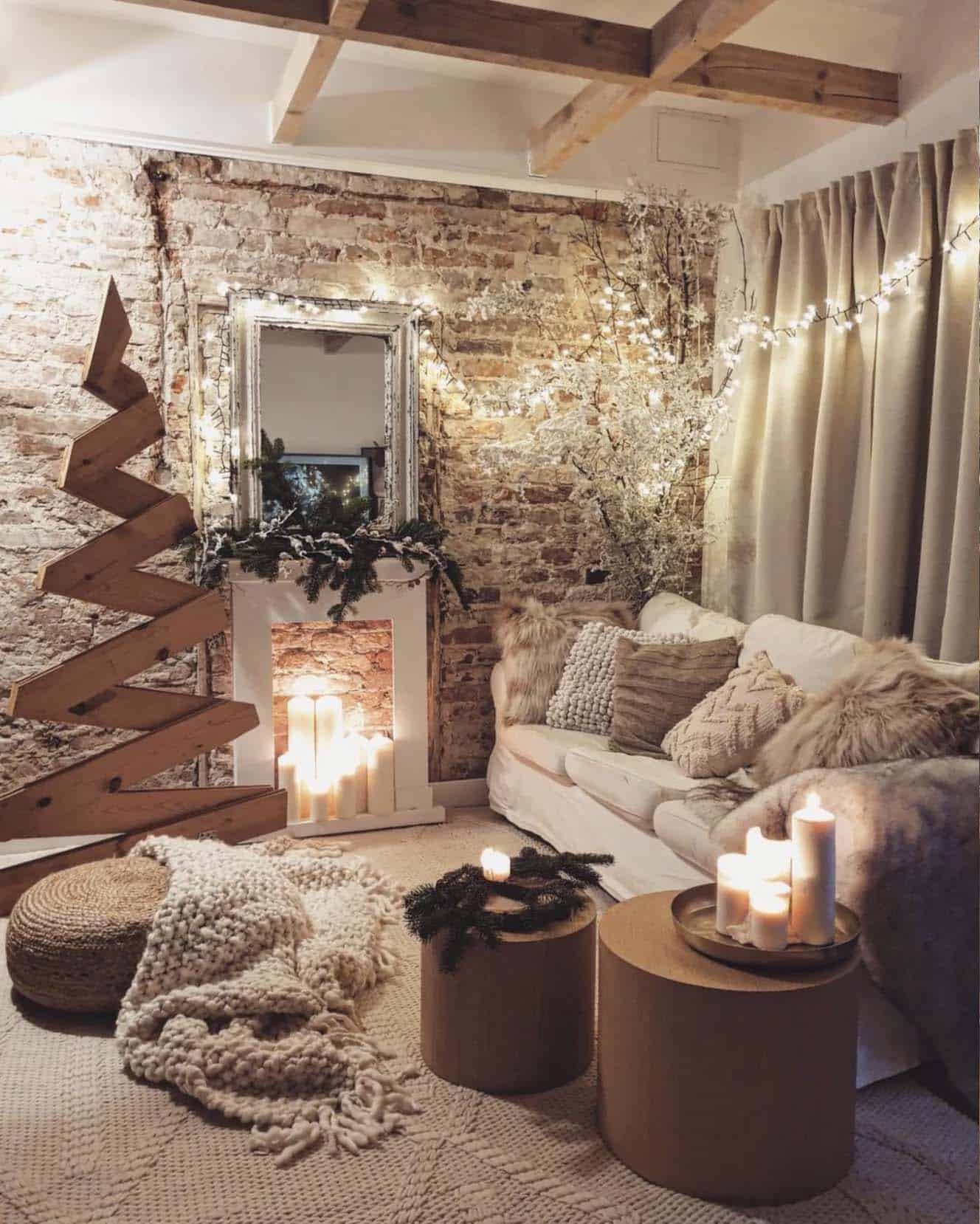 Christmas decorated living room with a wood tree and fireplace with candles