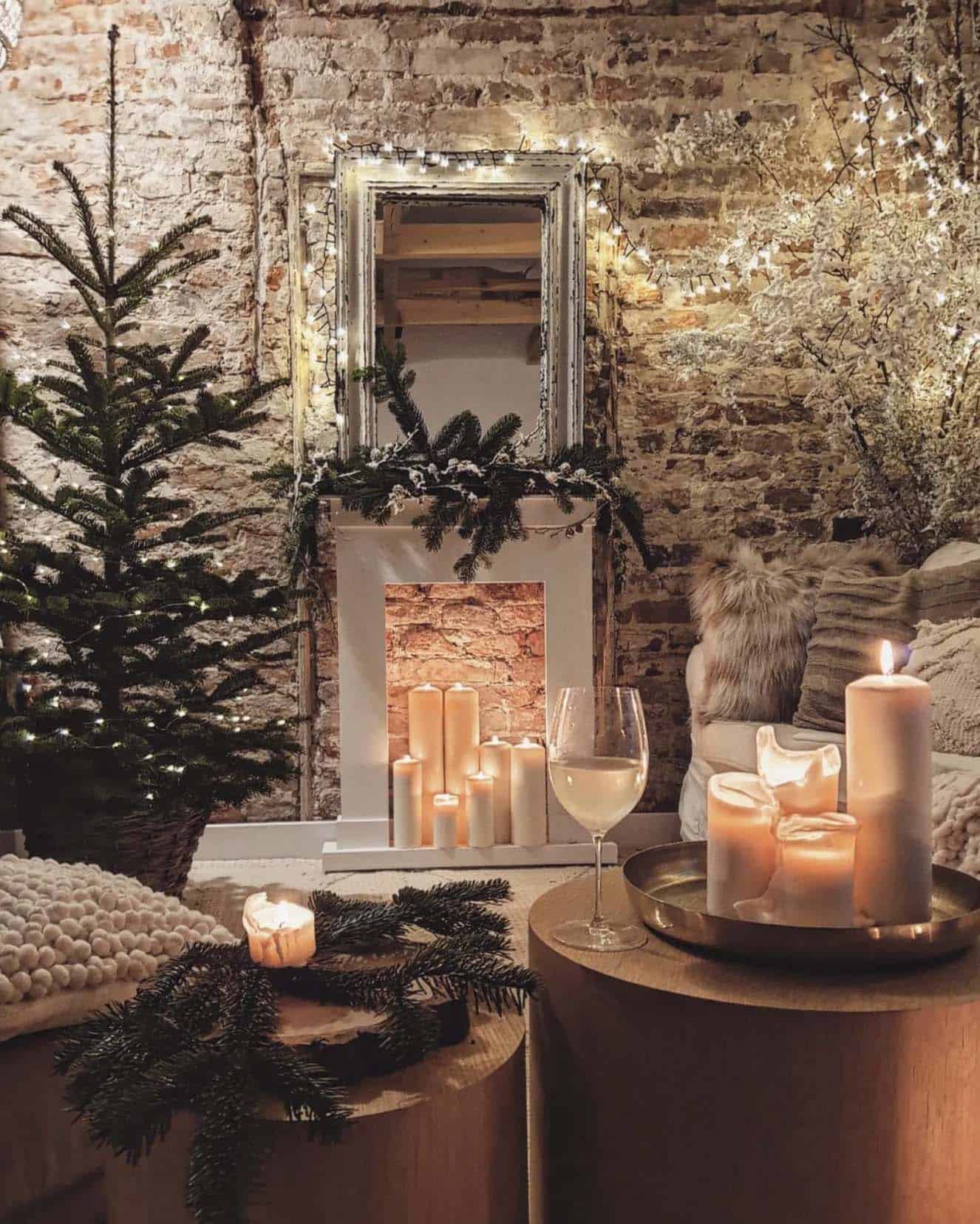 living room with a christmas tree and faux fireplace with candles