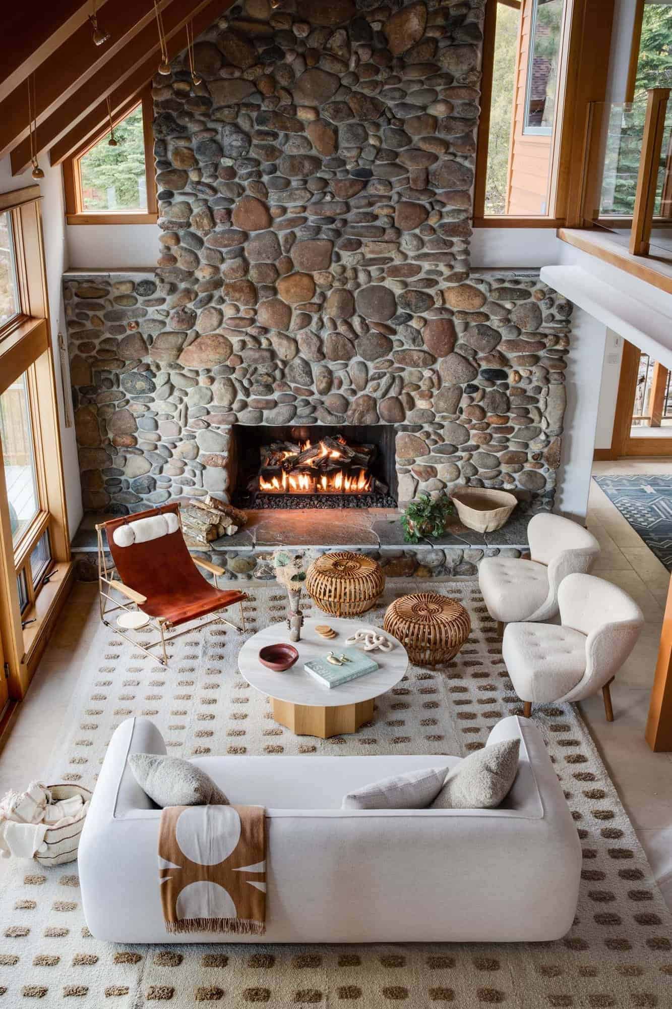 contemporary two-story living room with a massive stone fireplace