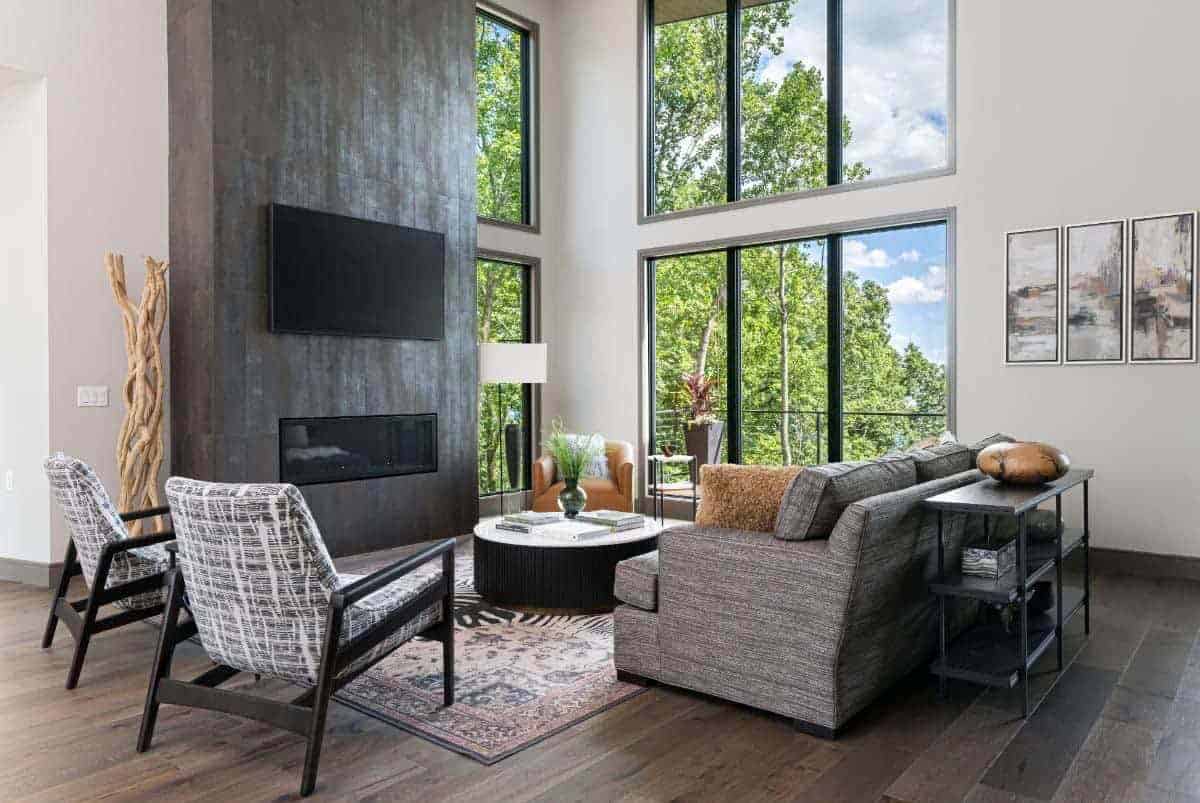 modern mountain style living room with a fireplace and large windows