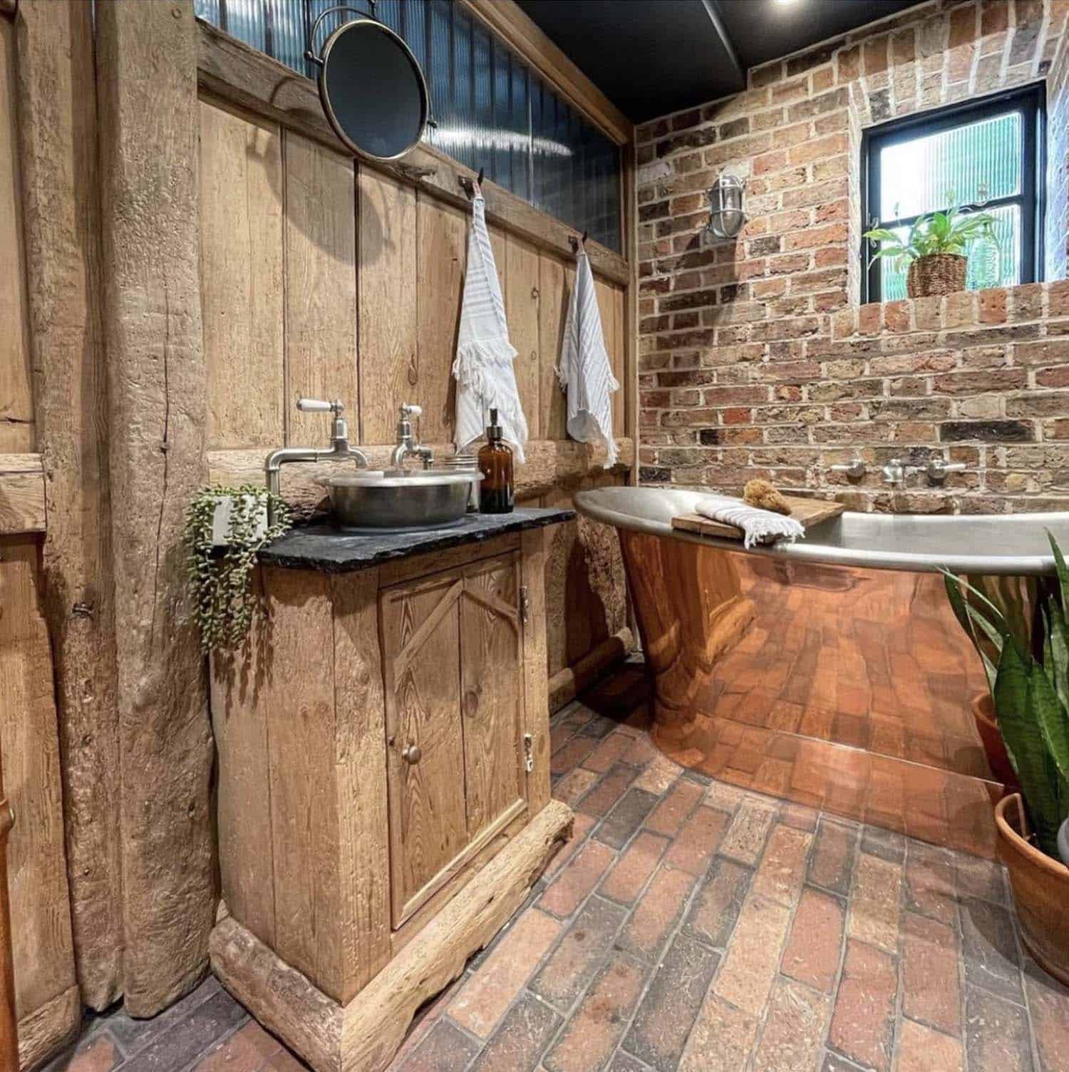 rustic barn bathroom with a copper tub