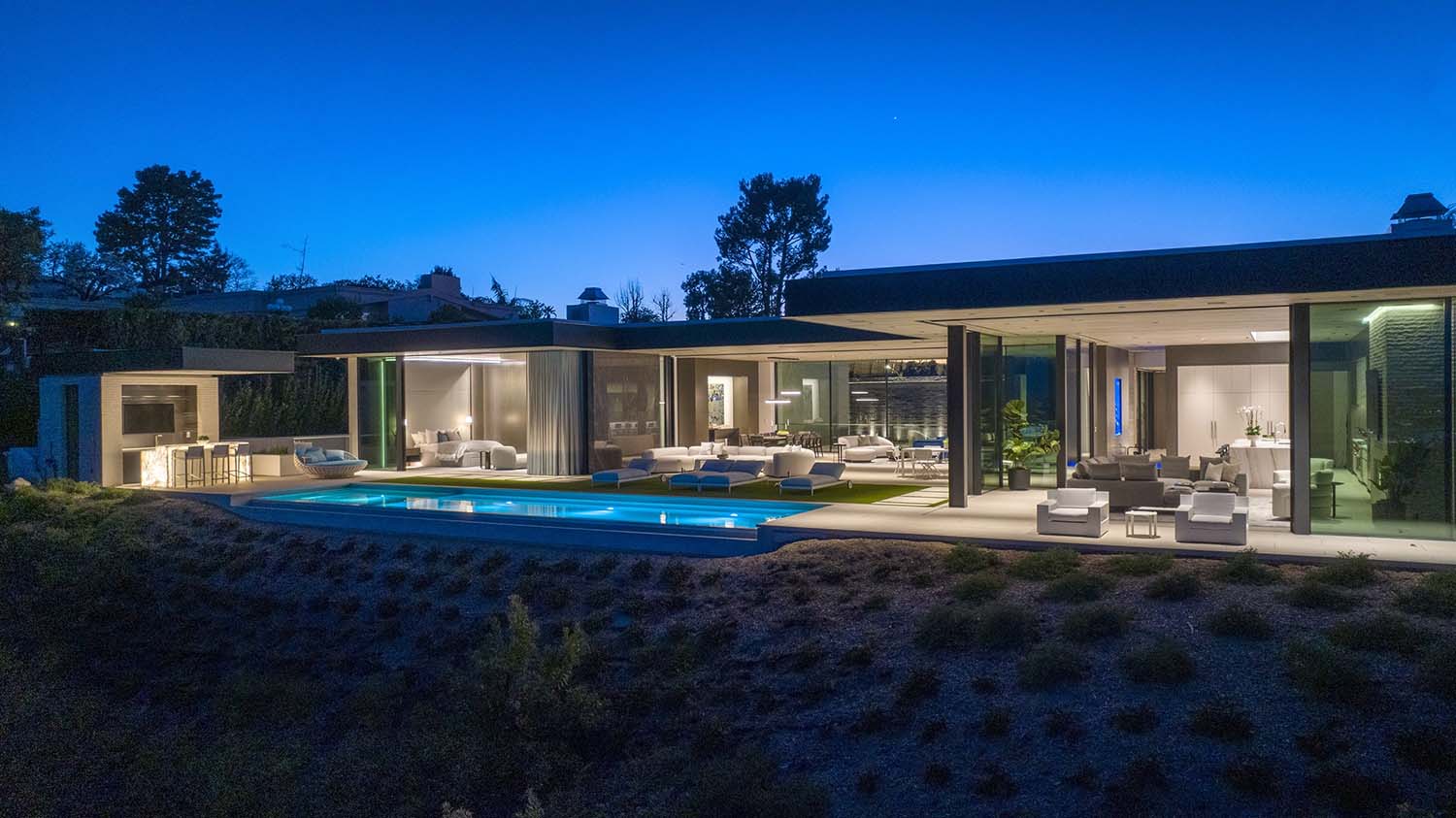 modern backyard swimming pool at dusk