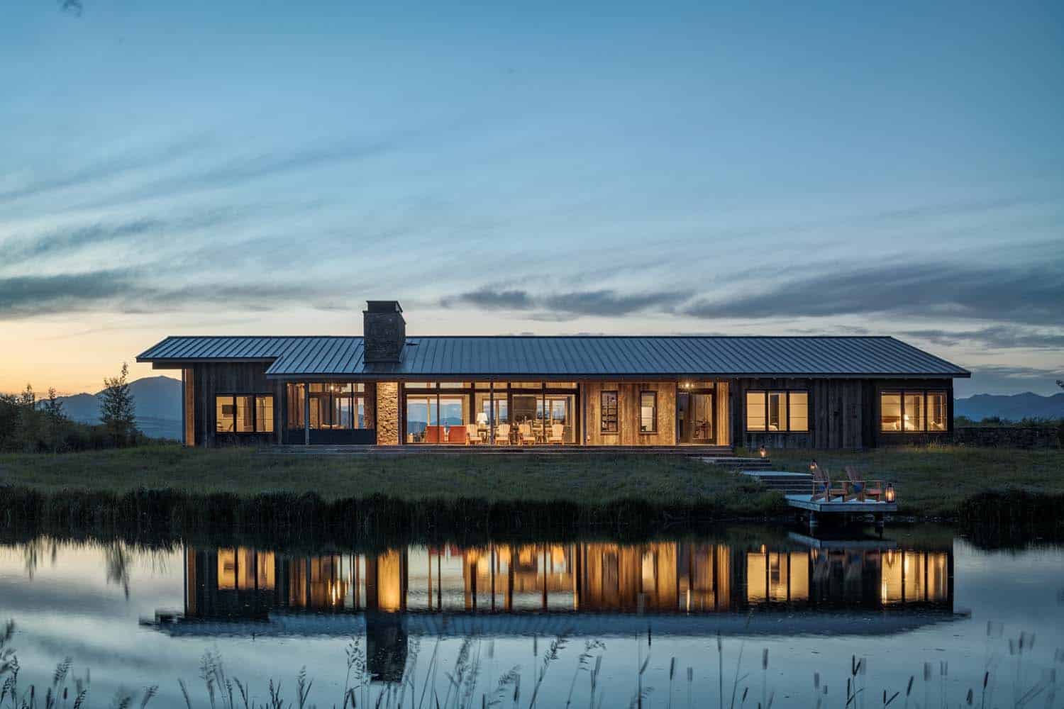 rustic home exterior with a view of the river at dusk