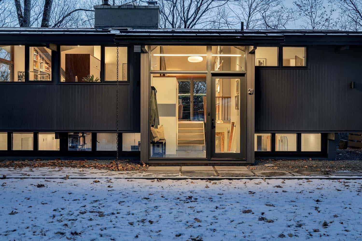 midcentury modern deck house exterior with snow at dusk
