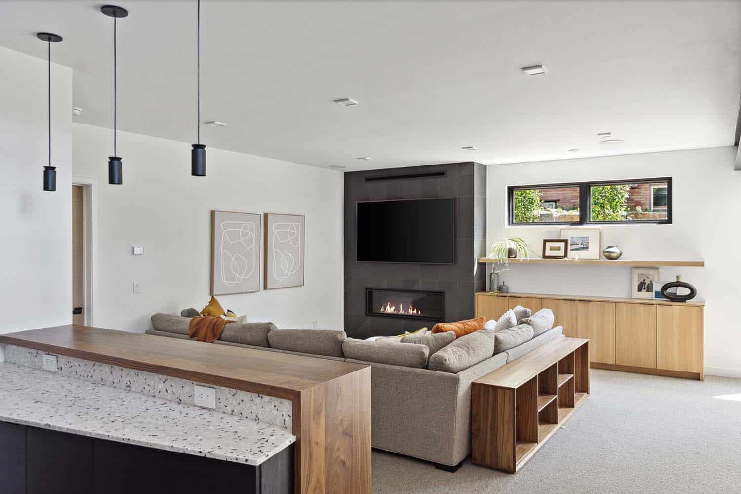 modern basement family room with a fireplace