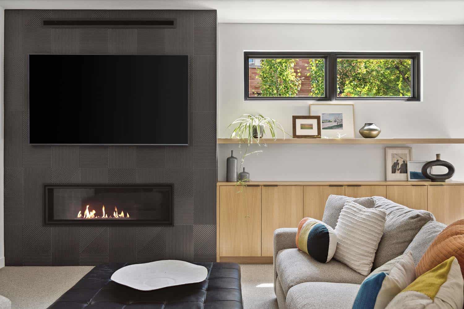 modern basement family room with a fireplace