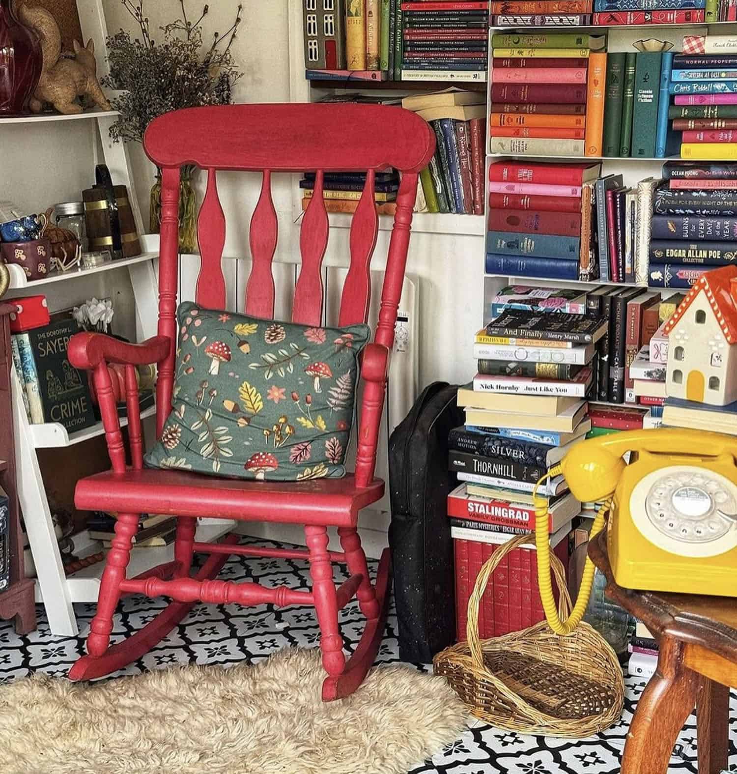 cozy shed reading nook with books and a red rocking chair