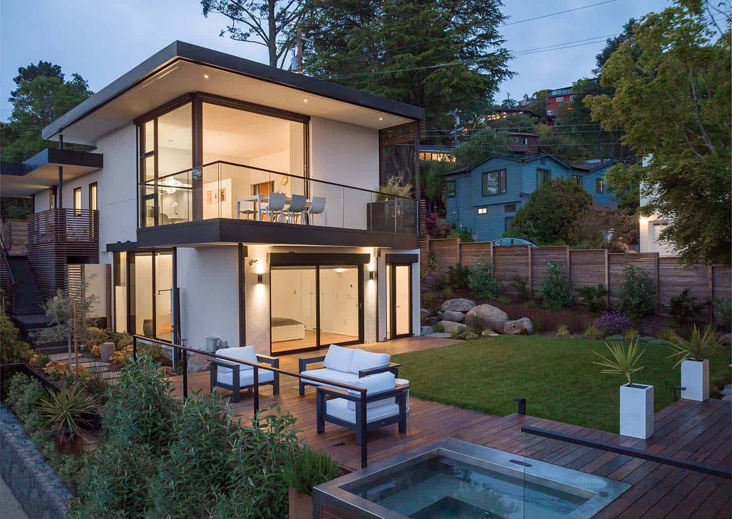 modern European style home exterior with a patio and spa at dusk