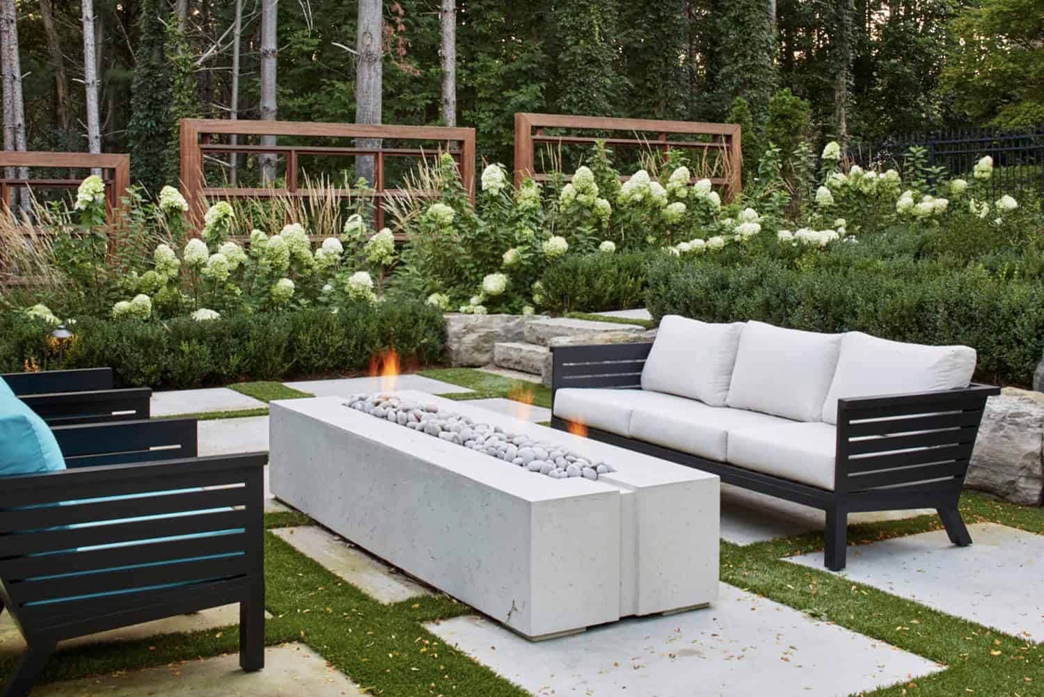 traditional landscape with a fire table and outdoor lounge chairs