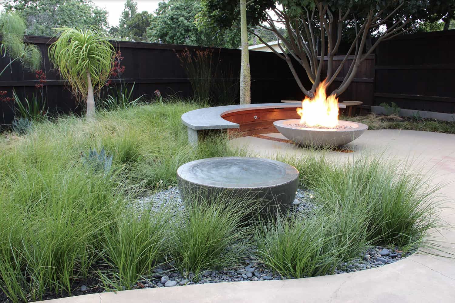 modern patio with a water feature and fire bowl