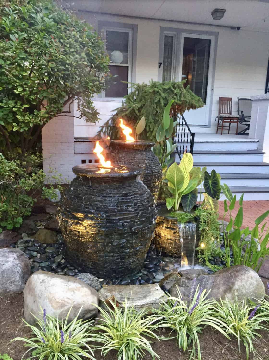 bubbling stone urns in a rock garden with aquatic plants