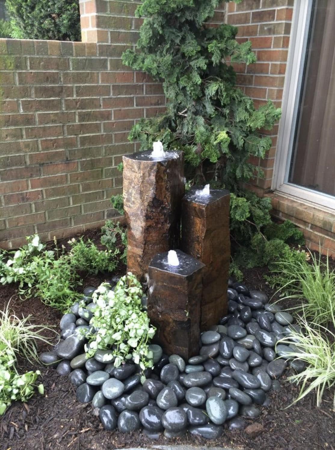 Basalt columns water feature with river rocks
