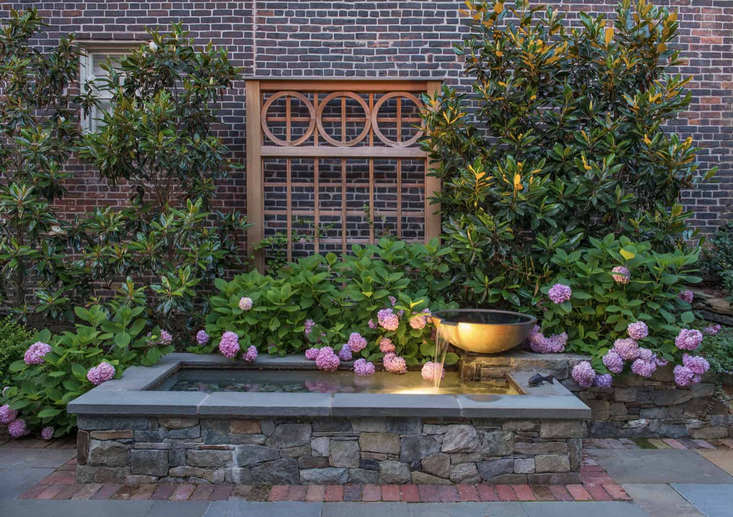 dish fountain with a brick wall backdrop