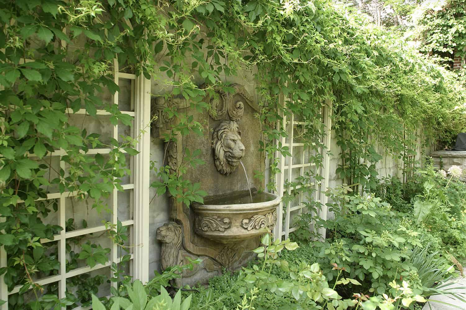 small English garden with a spitting lion water feature