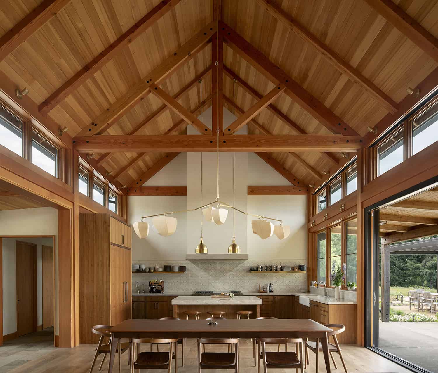 modern-dining-room-and-kitchen-with-a-vaulted-ceiling-and-disappearing-wall-of-glass