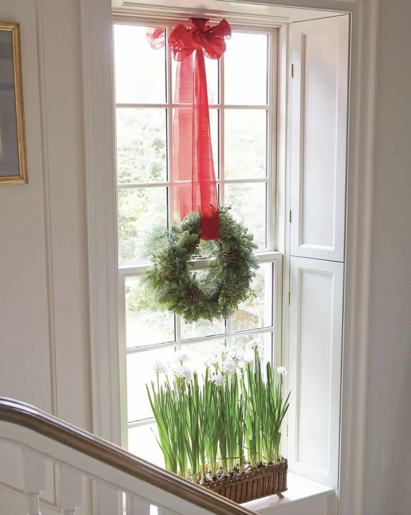 window-with-a-wreath-hanging-from-a-red-bow-and-paper-whites-on-the-window-ledge