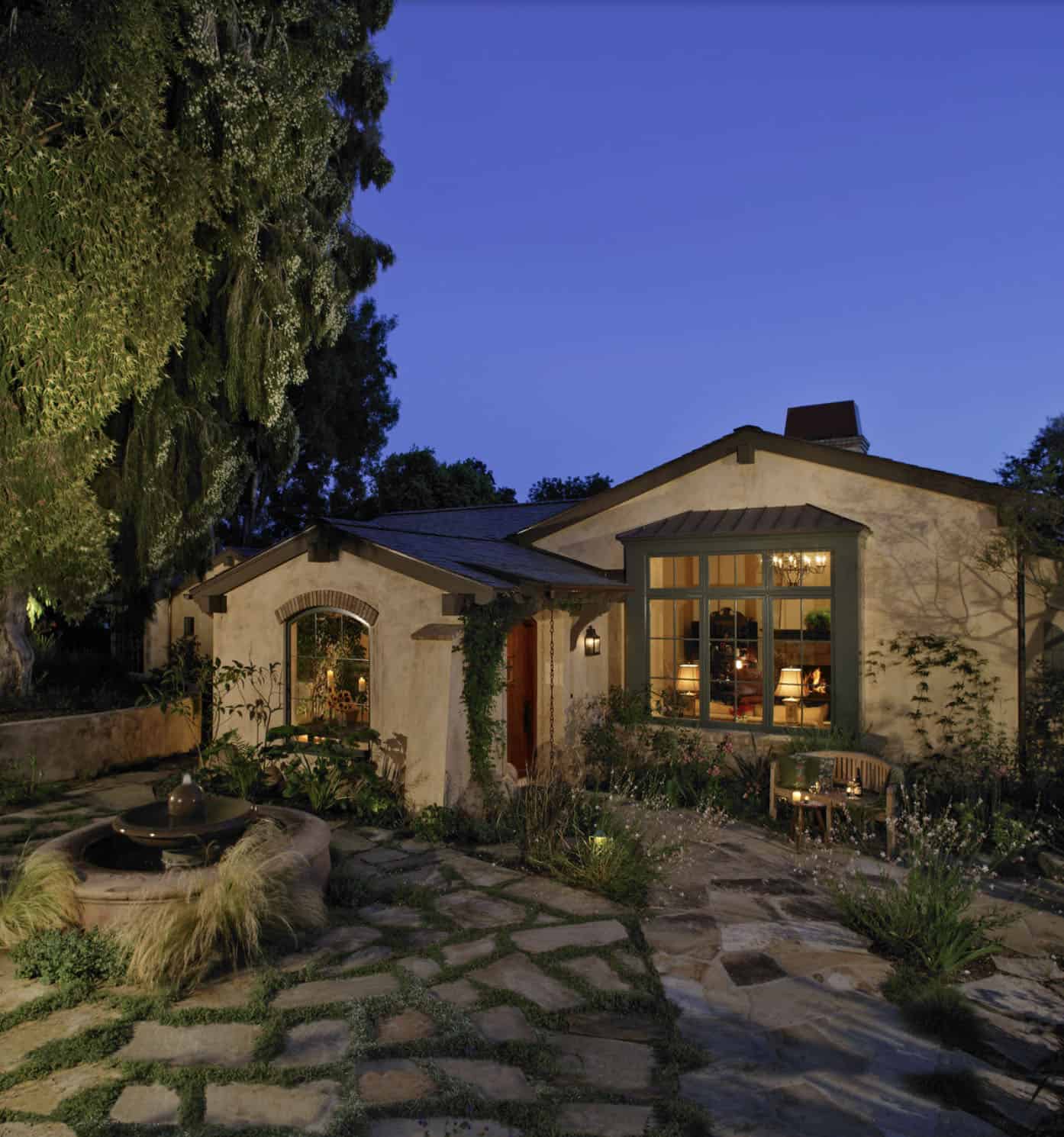 mediterranean-style-garden-cottage-exterior-and-landscaping-at-dusk