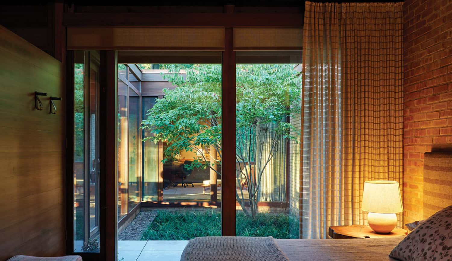 midcentury modern bedroom with a sliding glass door overlooking a central courtyard