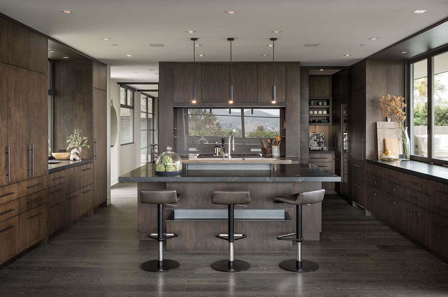 midcentury modern kitchen with three bar stools and pendant lights over the island