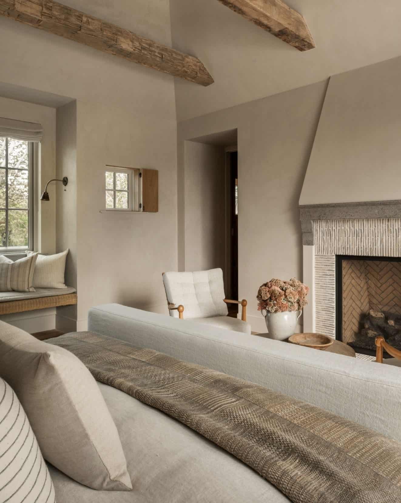 farmhouse style bedroom with an antique limestone fireplace mantel