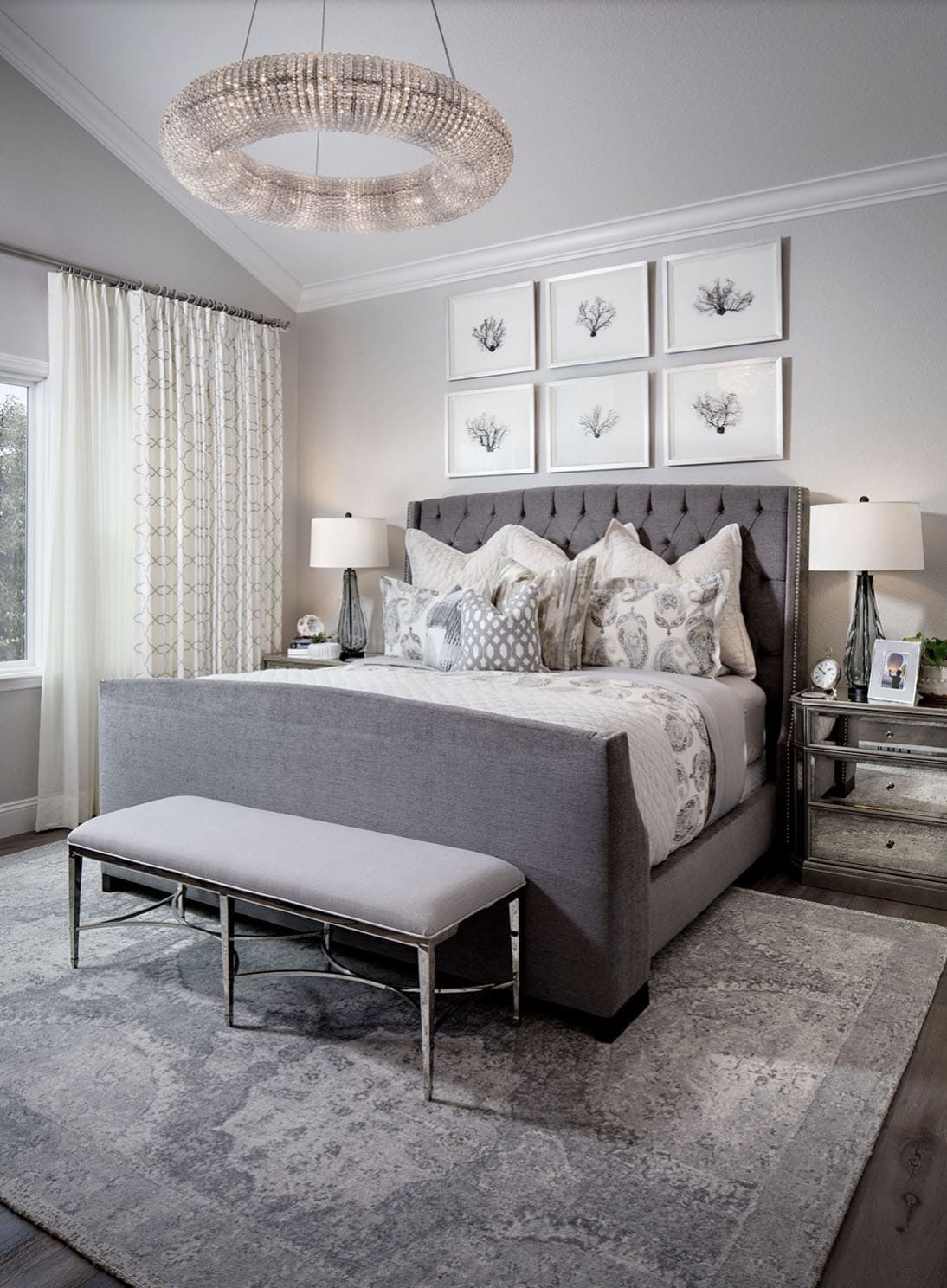 contemporary bedroom with artwork above the above the headboard and a large chandelier