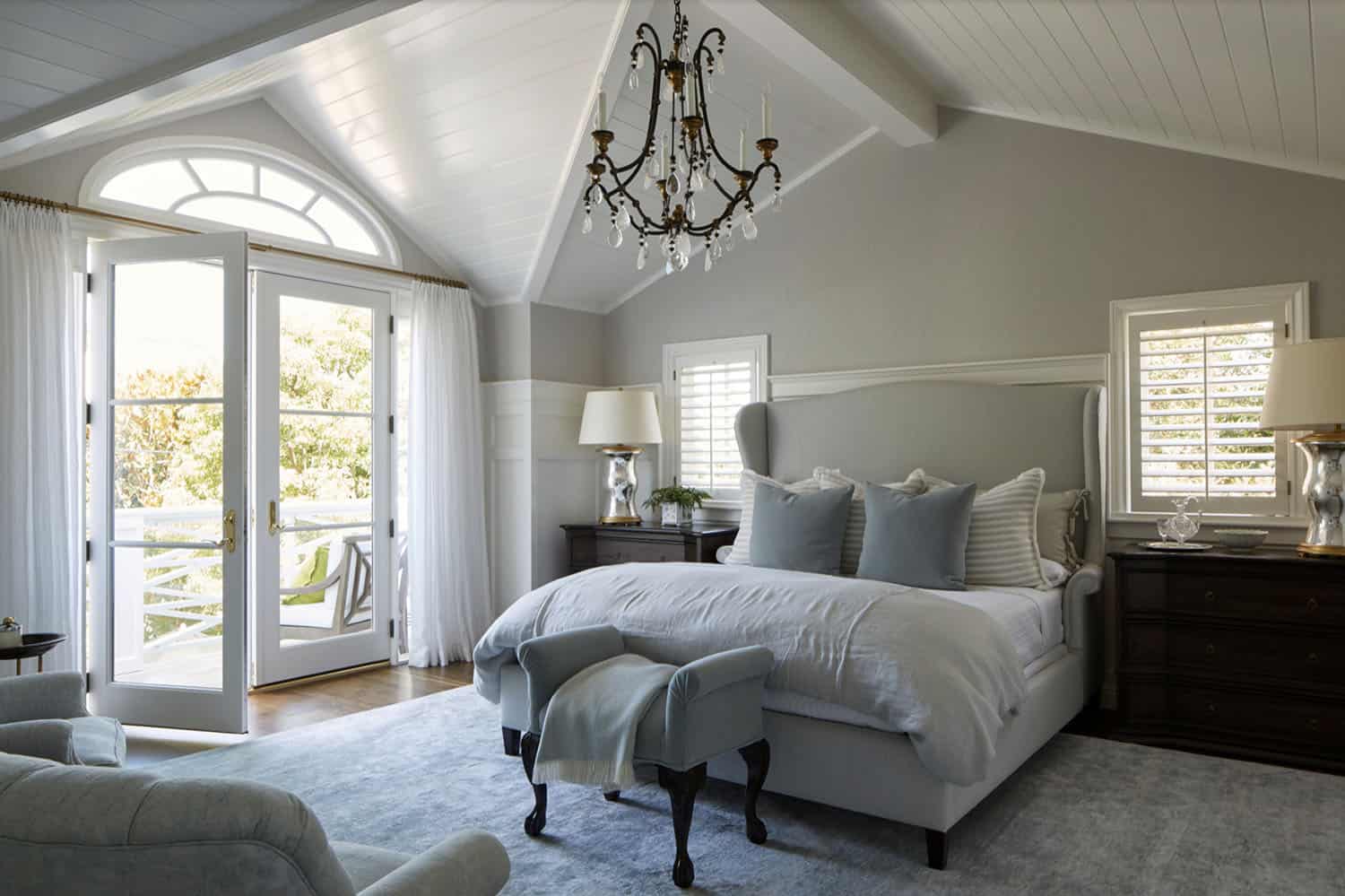 timeless traditional style bedroom gray painted walls, a vaulted ceiling and a large chandelier