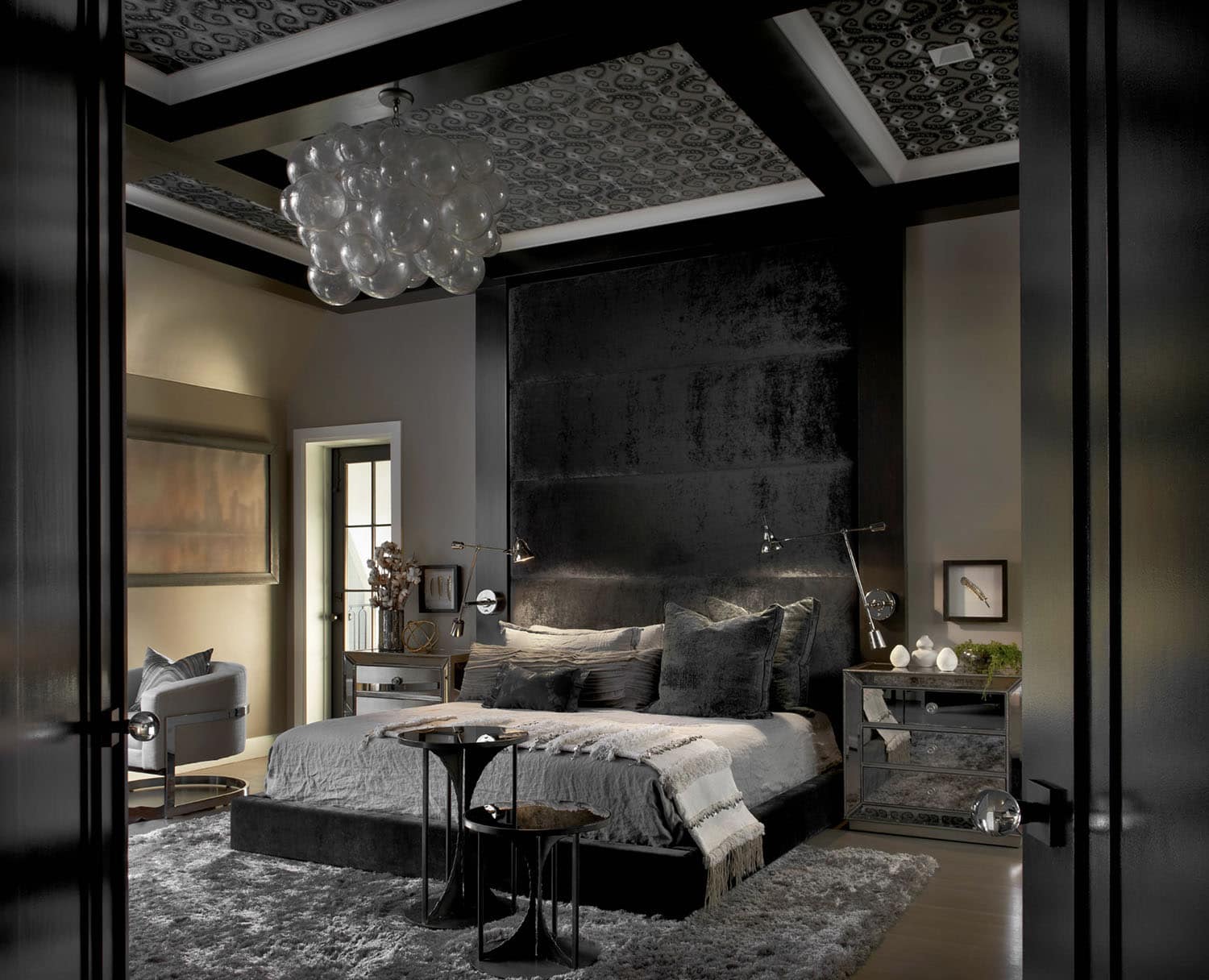 luxurious bedroom with dark gray walls and a chandelier