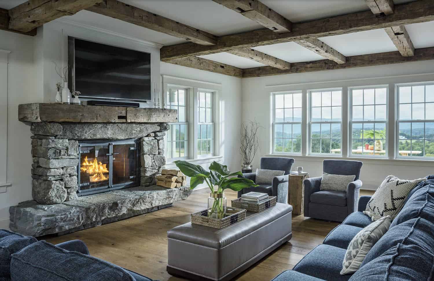 rustic modern living room with a stone fireplace and wood ceiling coffers