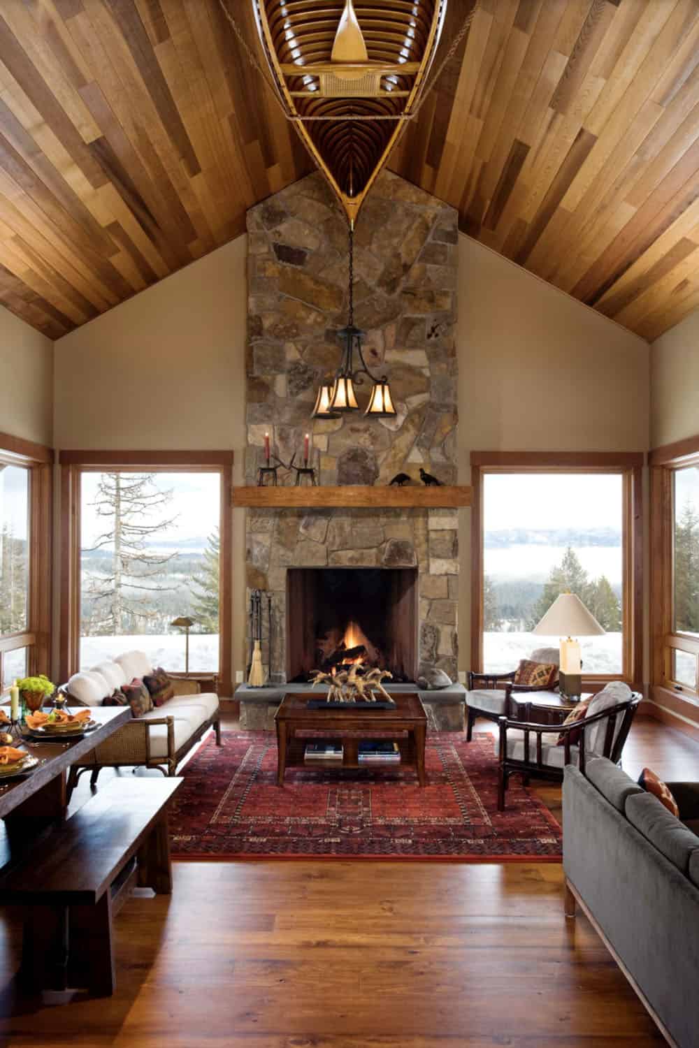 rustic modern living room with a stone fireplace and large windows