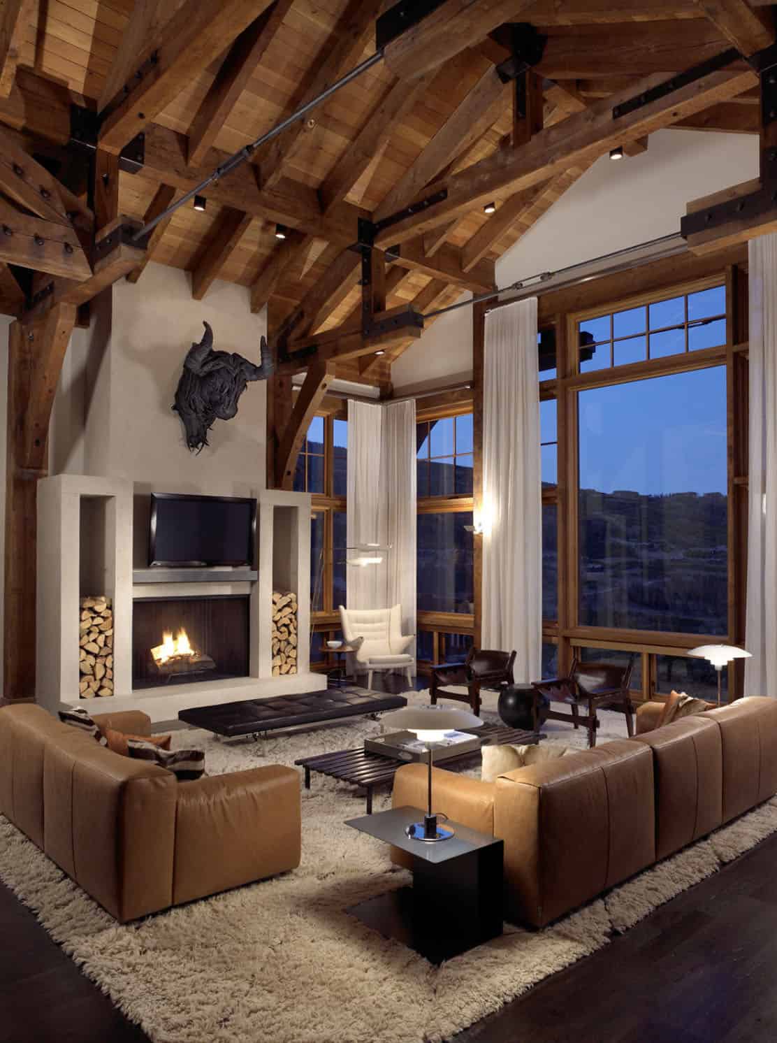 rustic modern living room with a fireplace and ceiling trusses