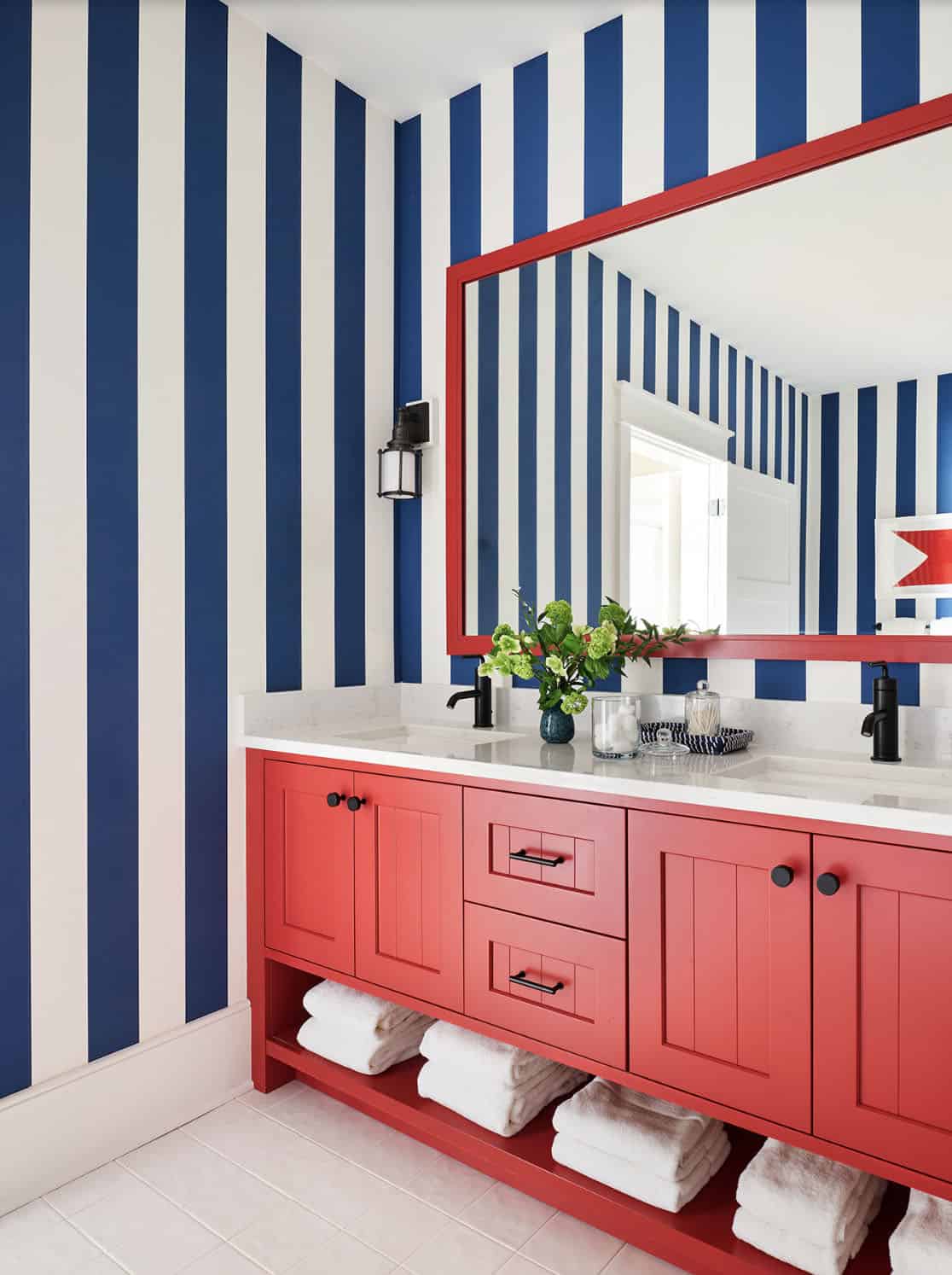 beach style bathroom with a red vanity and white countertop and blue and white striped walls