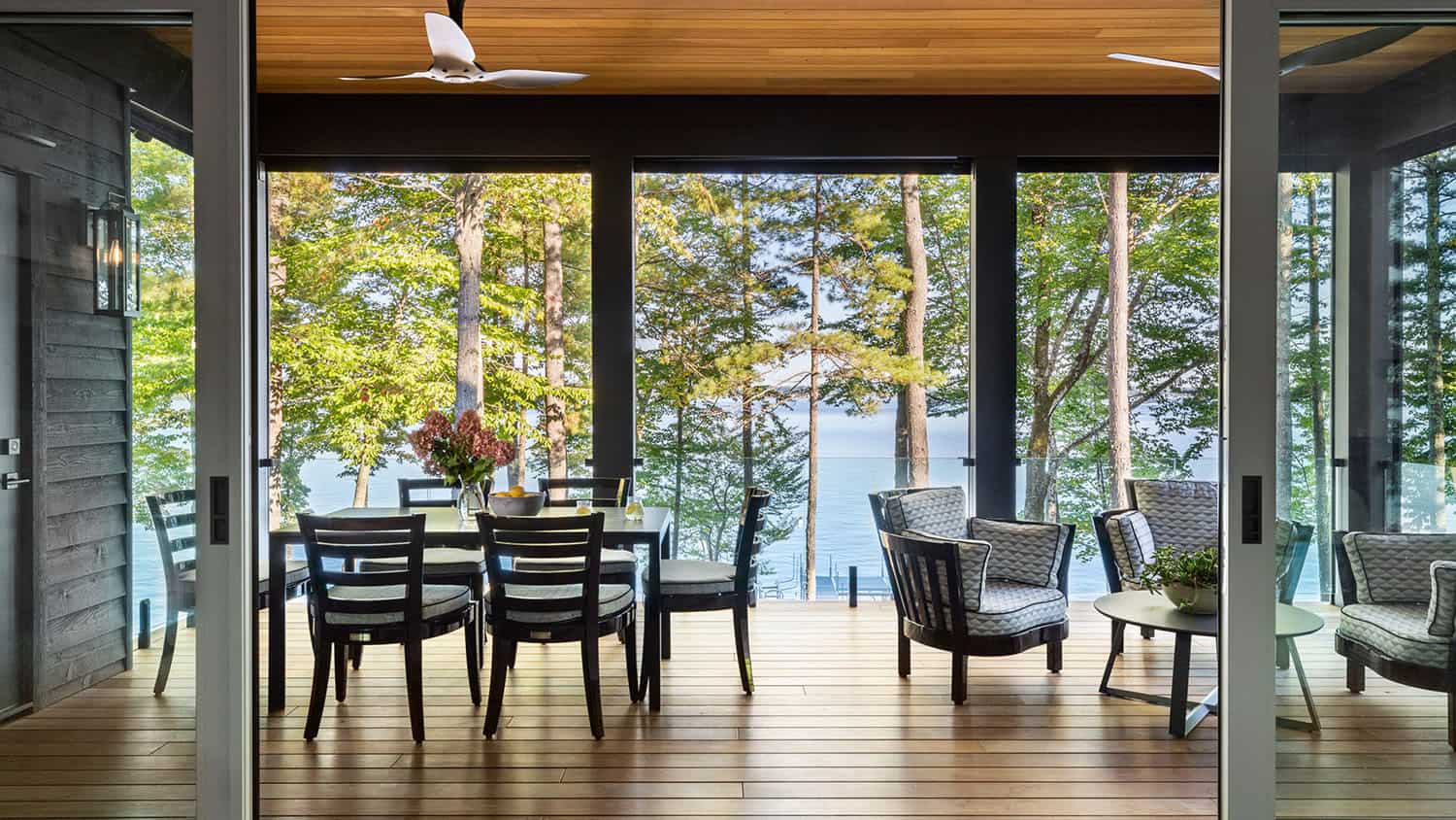 contemporary dining room with sliding glass doors overlooking the lake