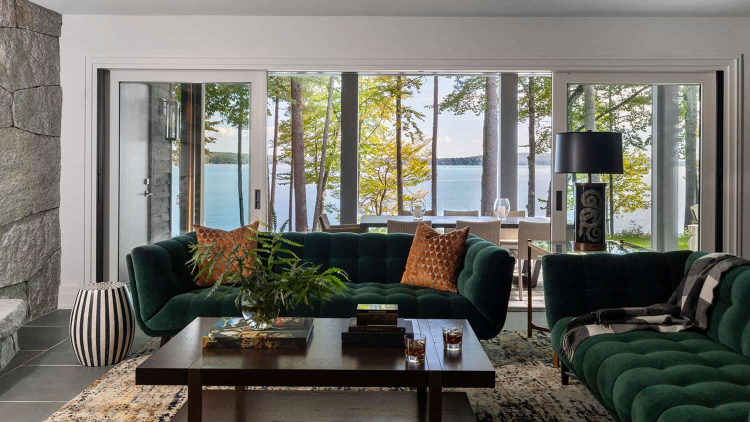 contemporary family room with large windows framing the lake