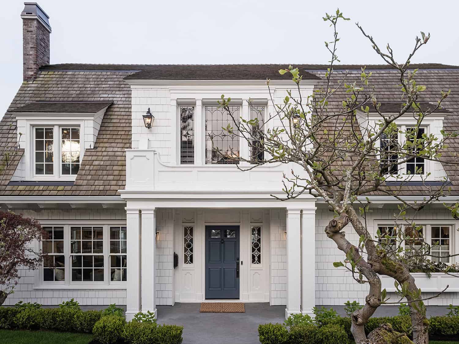 dutch colonial style home exterior with a blue door
