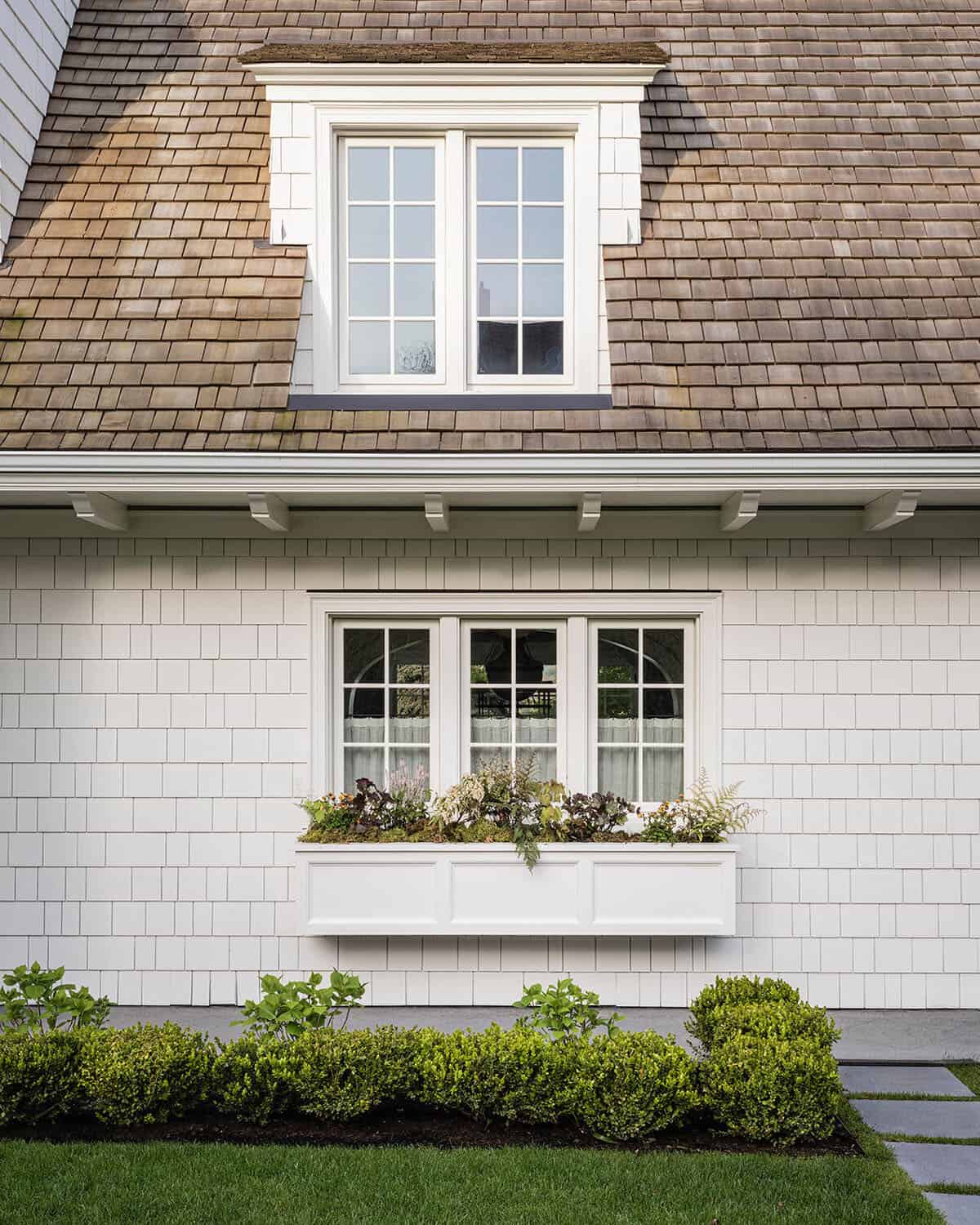 dutch colonial style home exterior with a window box
