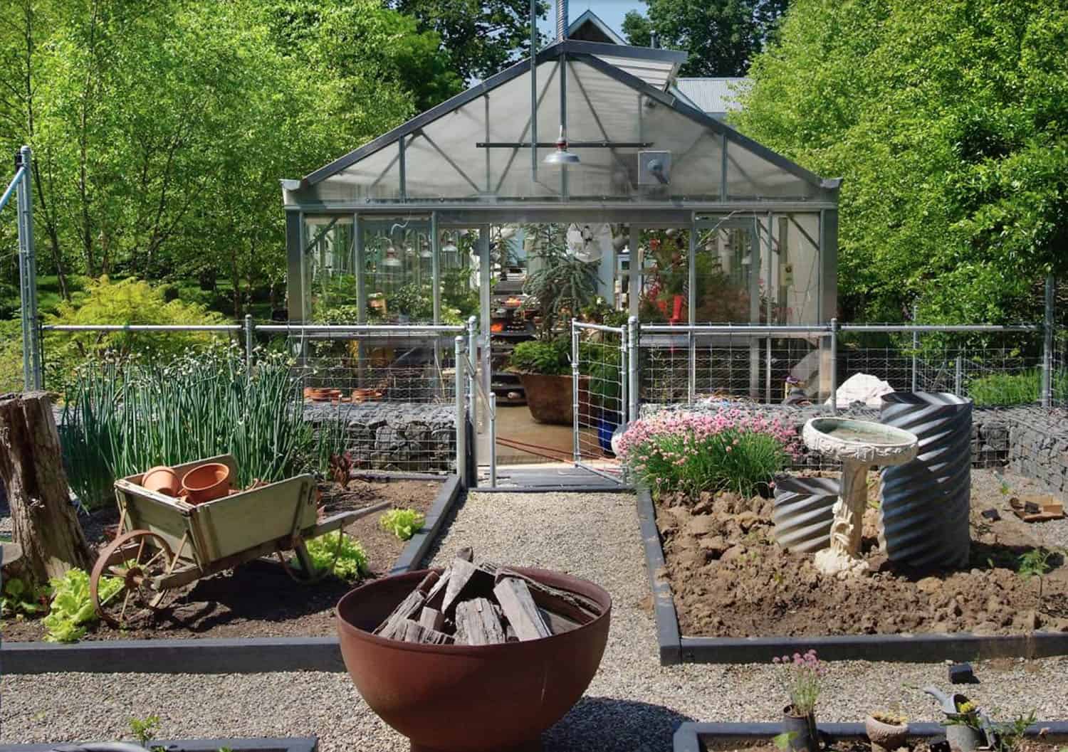 greenhouse exterior with a garden and fire pit