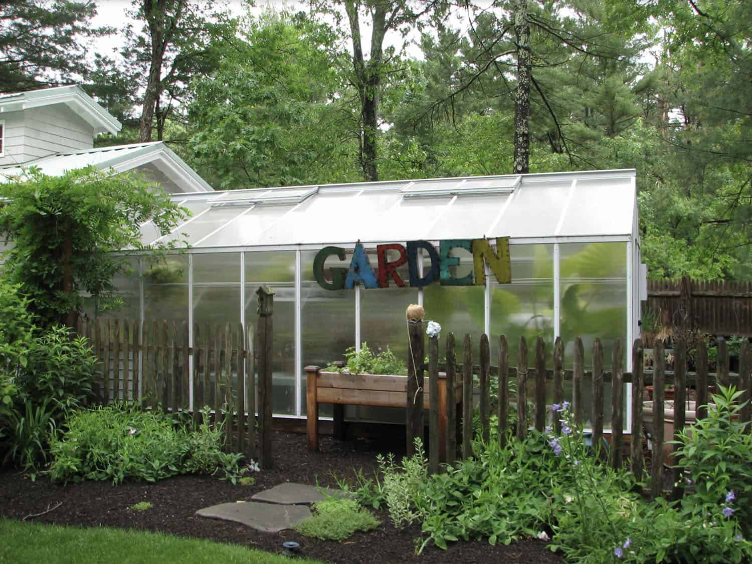 greenhouse exterior with a metal sign