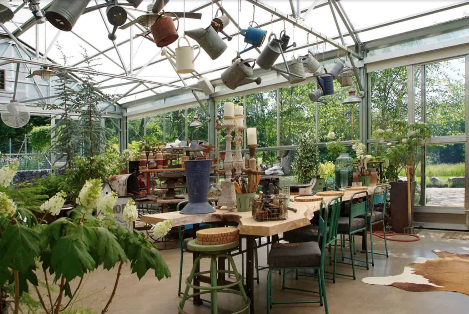 greenhouse interior with a dining table and hanging watering cans