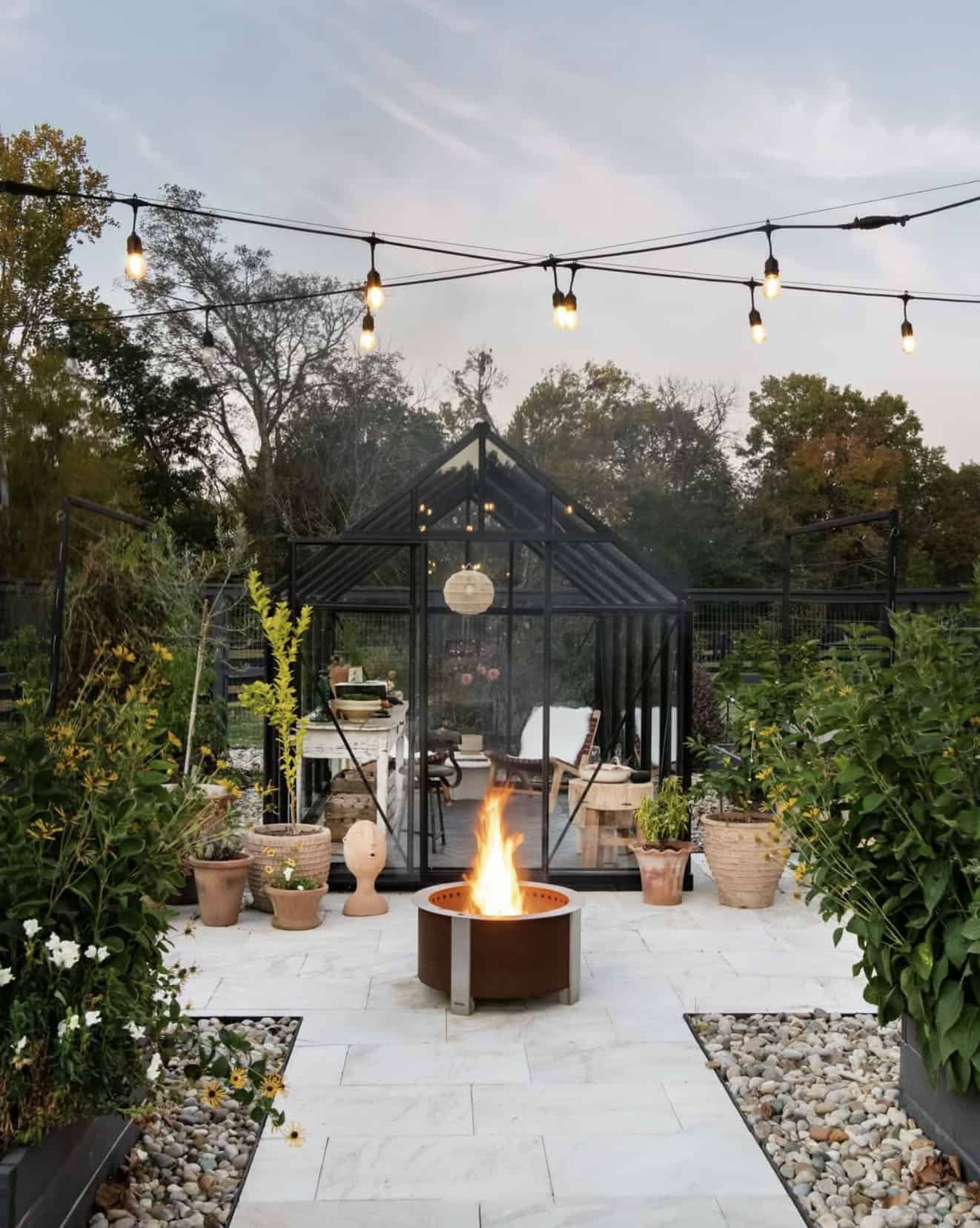 greenhouse exterior surrounded by gardens and a fire pit