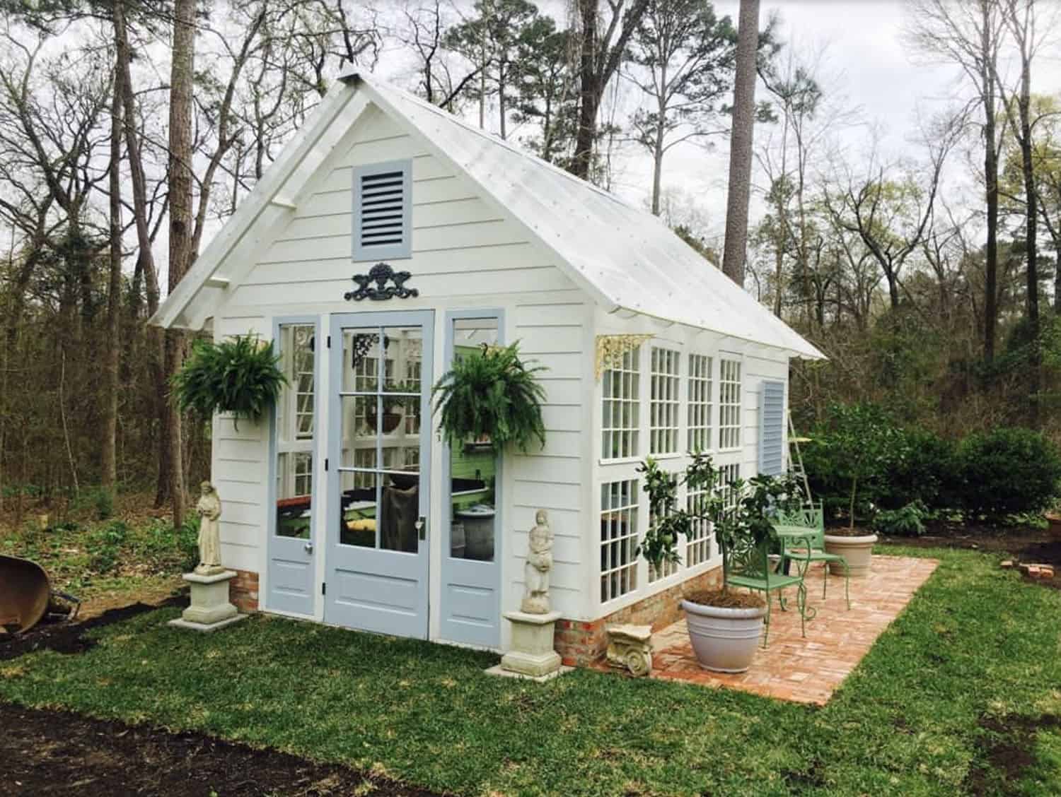 white-painted greenhouse exterior with blue doors