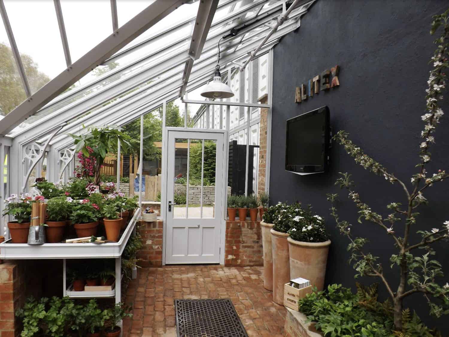 lean-to greenhouse interior with a potting station and black painted wall