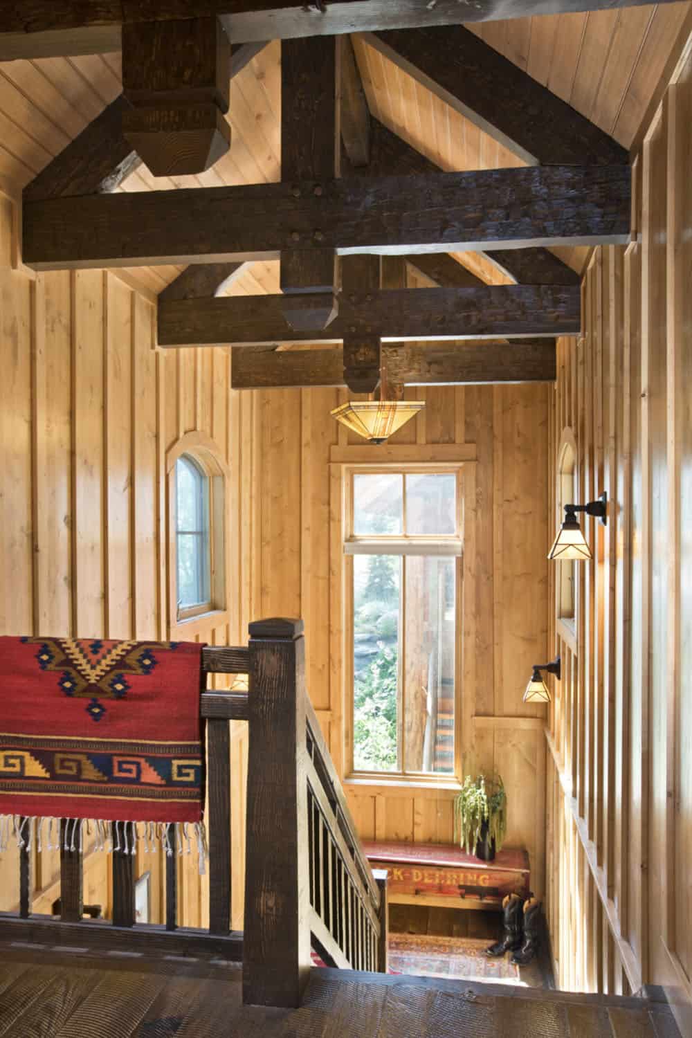 rustic staircase with exposed ceiling trusses