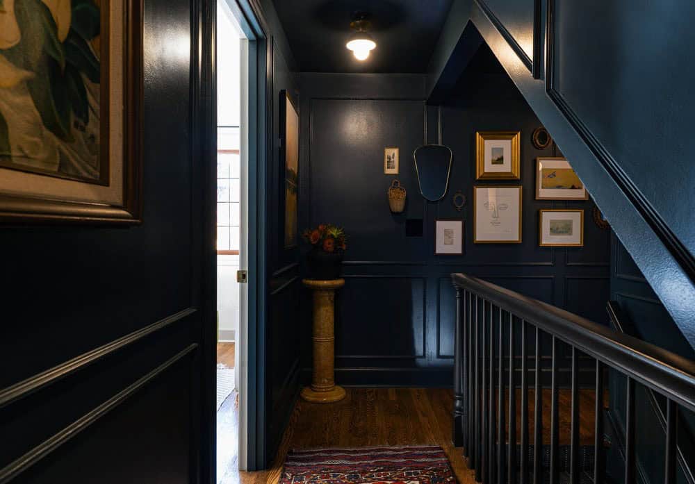 contemporary upstairs hallway with dark painted walls and artwork