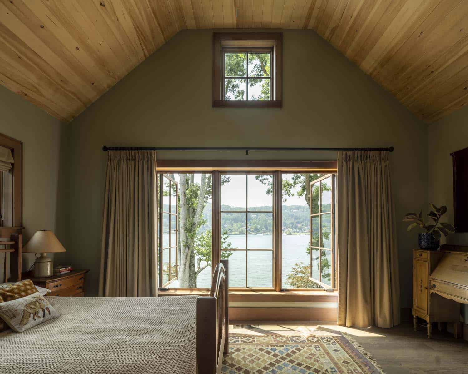 rustic bedroom with a large window and views of the lake