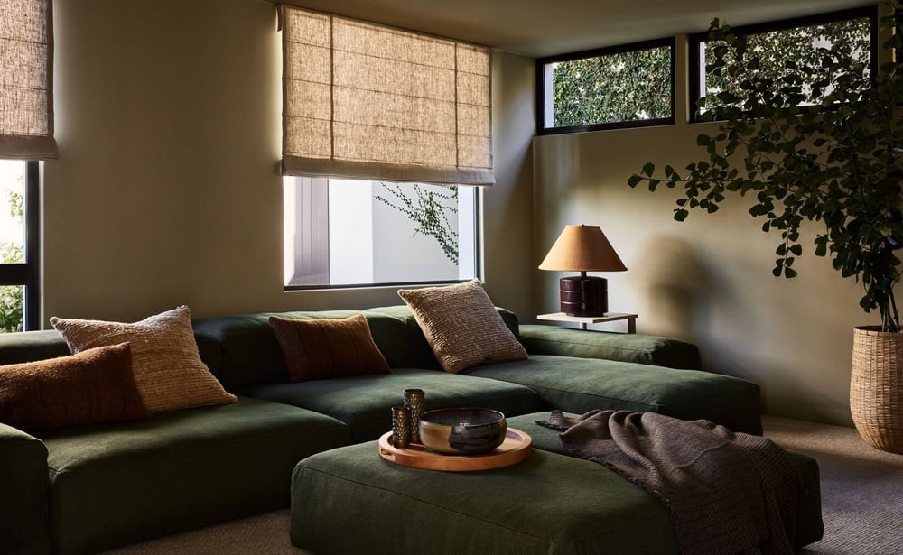 dark green couch and chairs with pillows