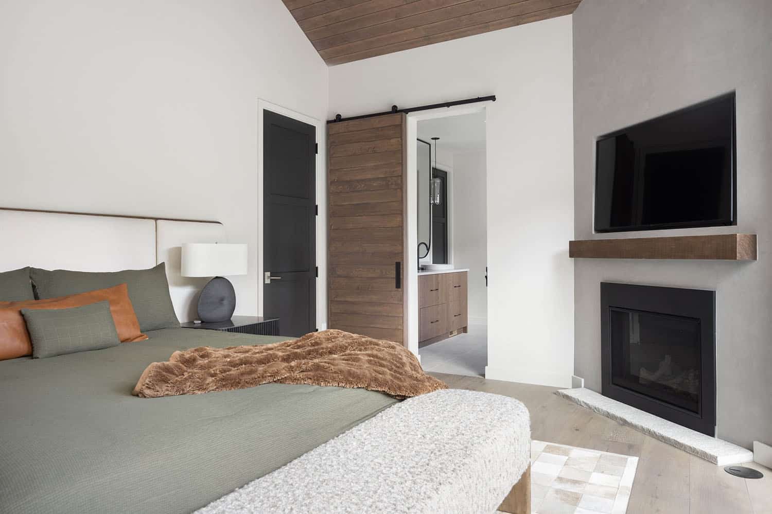 modern rustic bedroom with a fireplace and sliding barn door